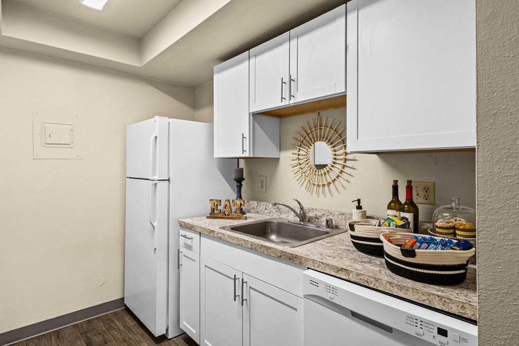 a kitchen with white cabinets and a sink and a refrigerator