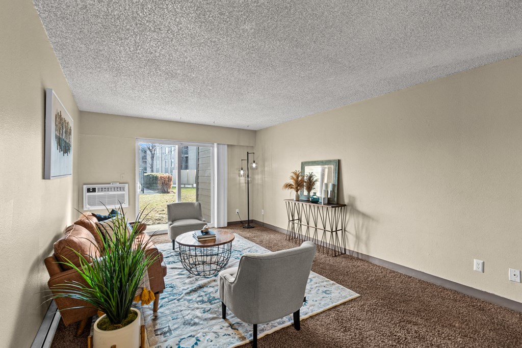 a living room with a couch and chairs and a rug