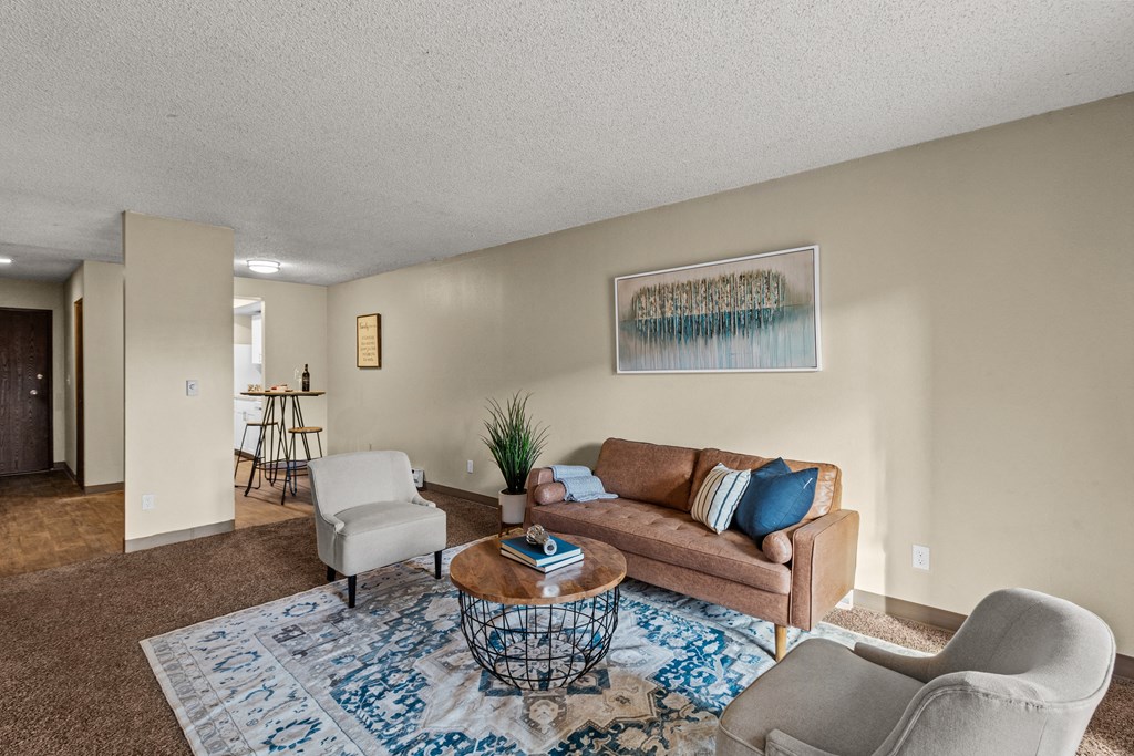 Cedar North Apartments living room with a couch and chairs and a coffee table