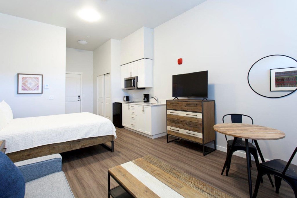 a bedroom with a bed and a desk and a television