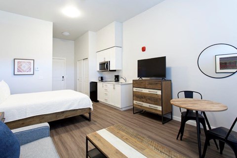 a bedroom with a bed and a desk and a television
