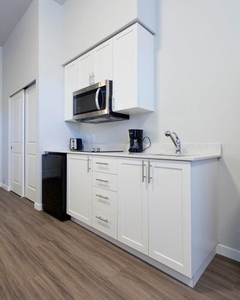 a kitchen with a microwave and white cabinets