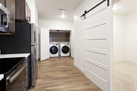 A white door is open in a modern kitchen.