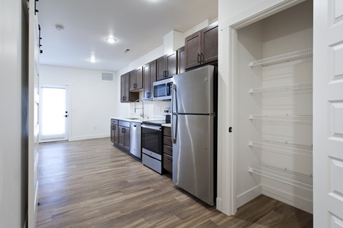 A kitchen with a refrigerator, microwave, and oven.