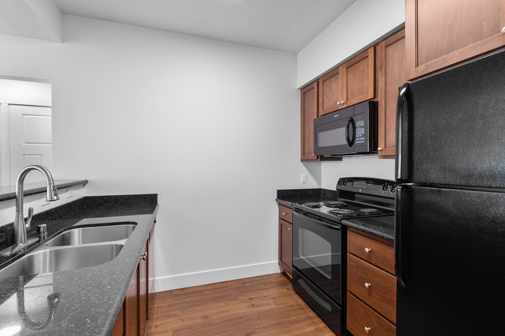 a kitchen with wood cabinets and black appliances