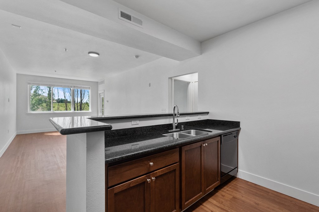 a kitchen with dark wood cabinets and granite countertops