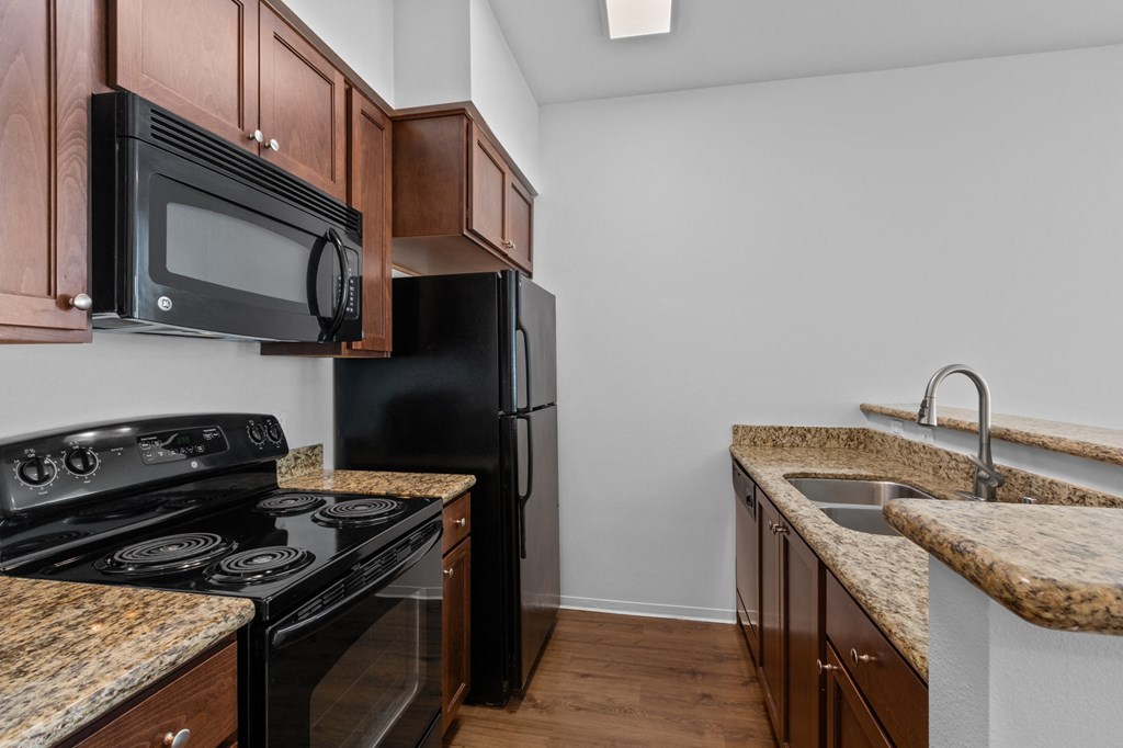 a kitchen with granite countertops and black appliances