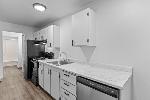a kitchen with white cabinets and a sink and a refrigerator