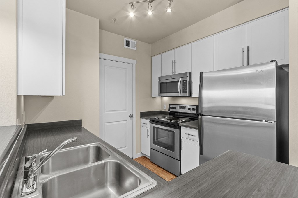 a kitchen with white cabinets and stainless steel appliances