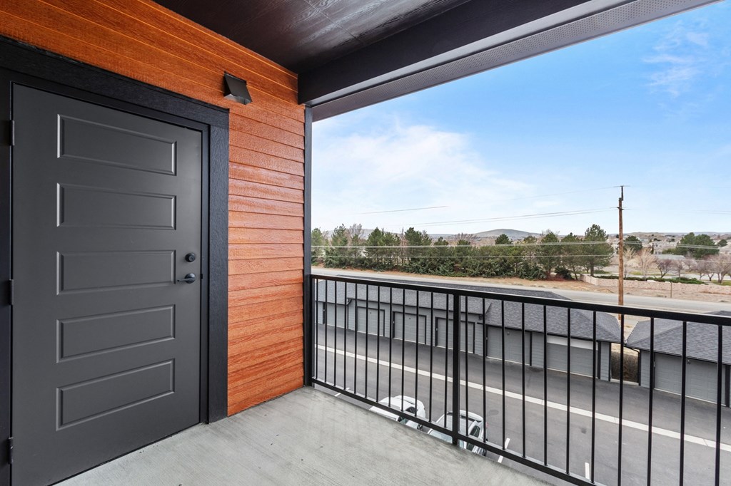 a balcony with a door and a street in the background