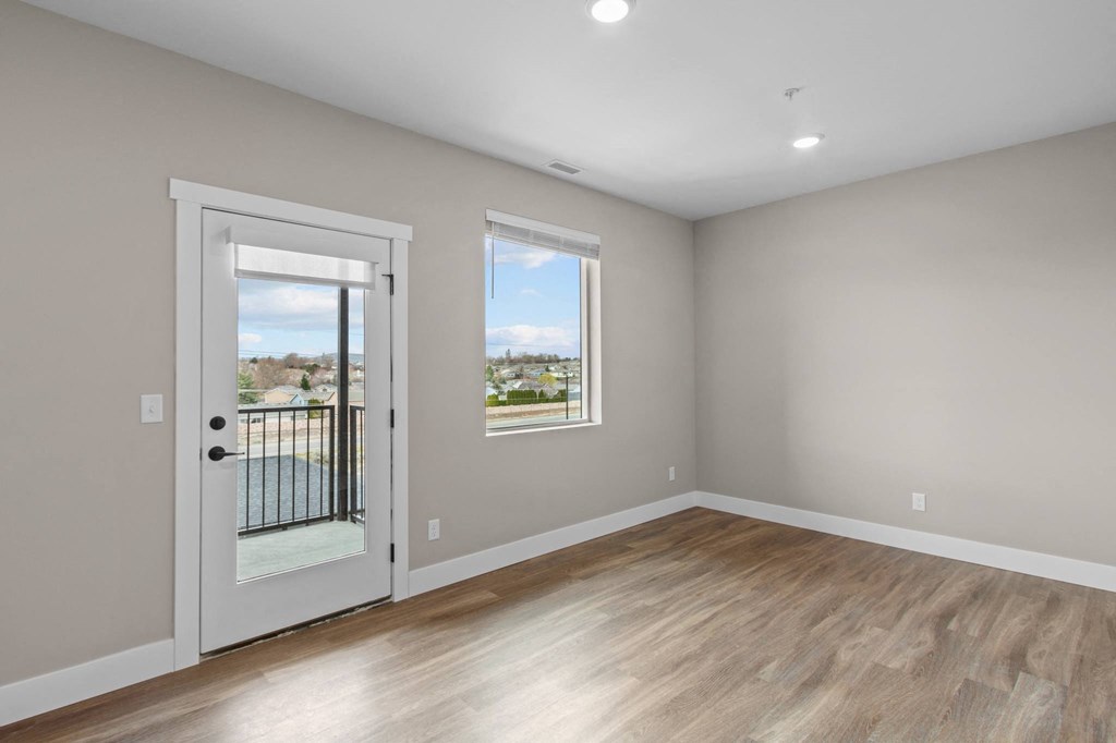 a bedroom with hardwood floors and grey walls