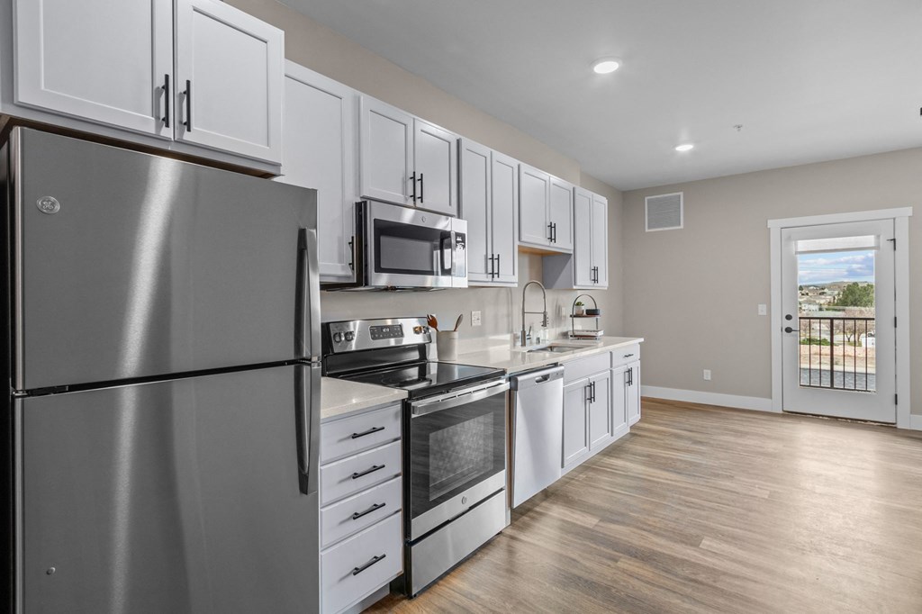 a kitchen with white cabinets and stainless steel appliances