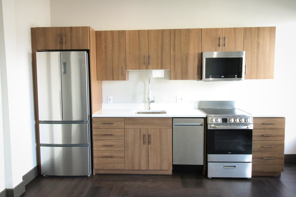 A modern kitchen with wooden cabinets and stainless steel appliances.