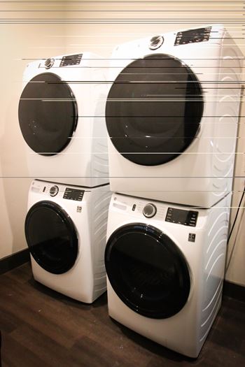 Two front load washing machines are stacked on top of each other.