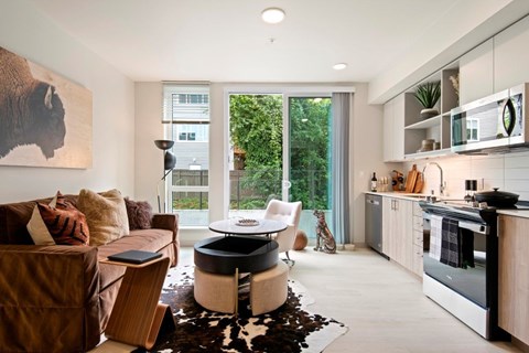 A modern living room with a brown couch and a cowhide rug.