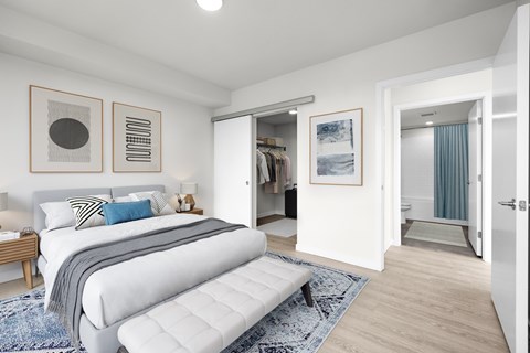 A bedroom with a large bed and a bench in the middle of the room.