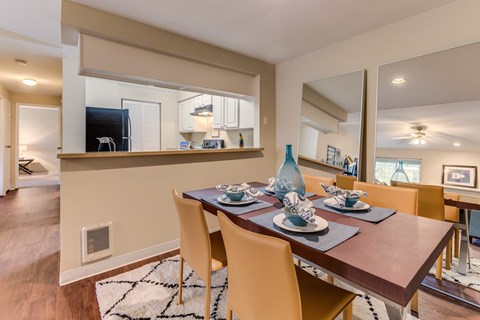 A dining room with a wooden table set for four.
