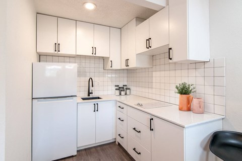 a kitchen with white cabinets and a white refrigerator