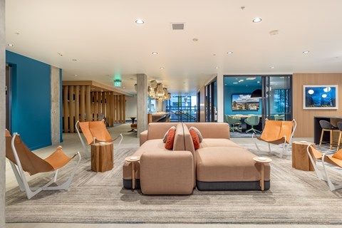 A spacious waiting area with orange chairs and a large couch.