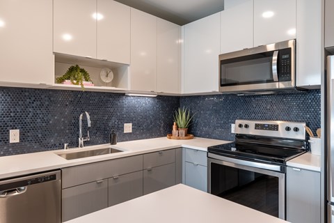 A modern kitchen with a stainless steel oven and white countertops.