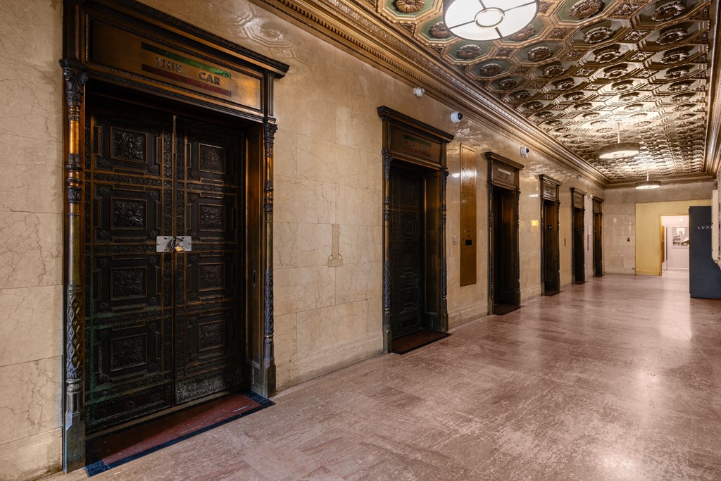 the lobby of a building with a row of elevators and doors