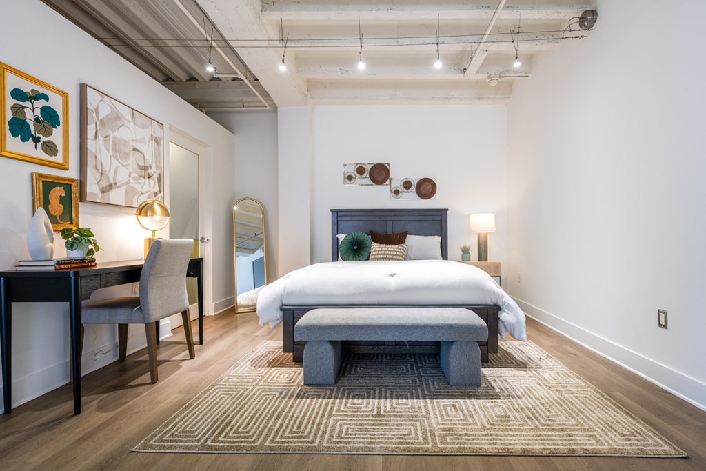 a bedroom with a bed and a desk with a chair