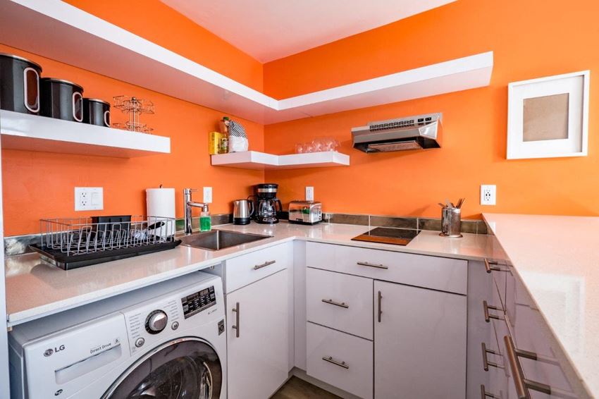 a laundry room with a washer and dryer and a counter with a sink