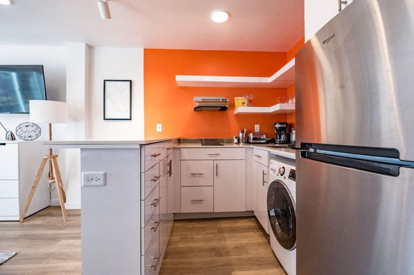 a kitchen with a washing machine and a refrigerator