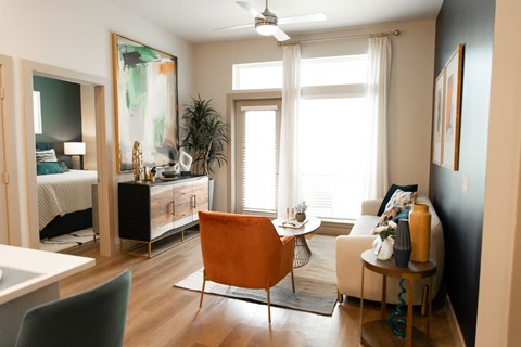 A living room with a chair, a table, and a painting on the wall.