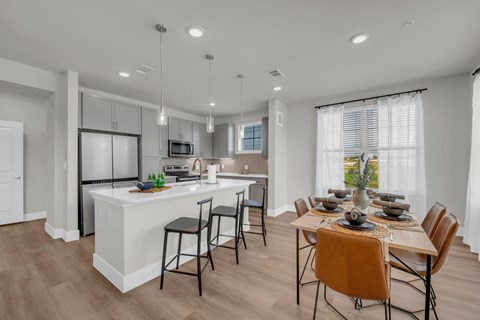 A modern kitchen with a dining table set for four.
