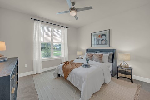 A bedroom with a large bed and a ceiling fan.
