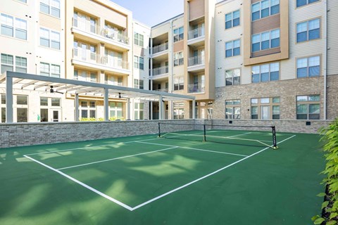 A tennis court is located in front of a building.