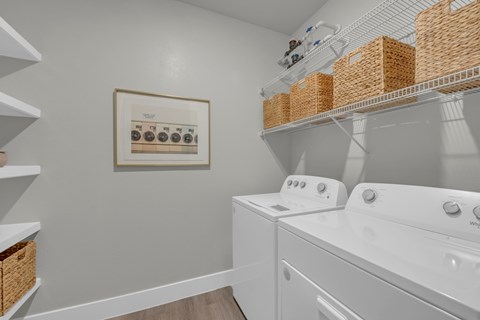A laundry room with washers and dryers and a basket on the shelf.