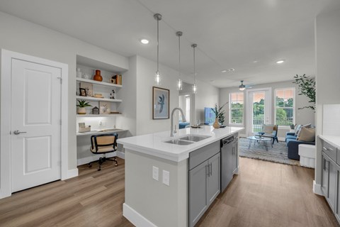 A modern kitchen with a large island and a view of the backyard.