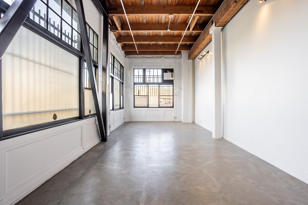 Santa Fe Art Colony  large white room with windows and a concrete floor