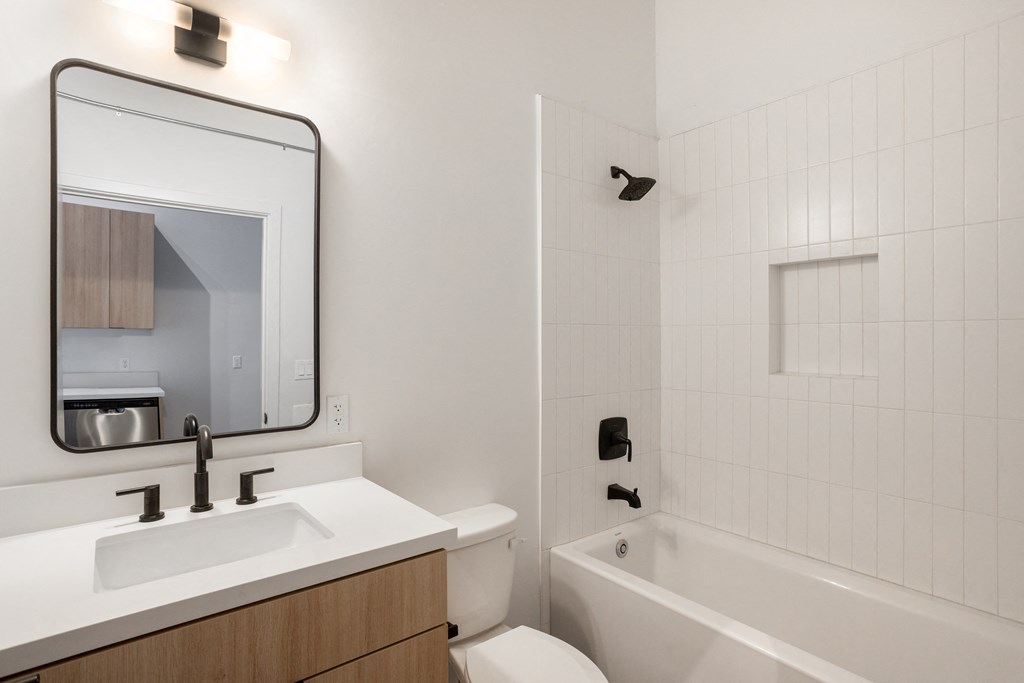 Santa Fe Art Colony bathroom with a sink and a tub and a mirror