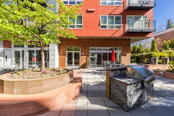 A modern building with a red brick facade and a landscaped courtyard.