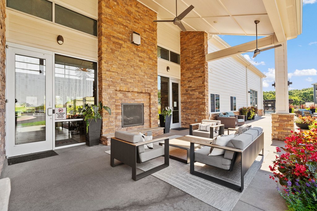 A patio with a table and chairs is covered by a roof.