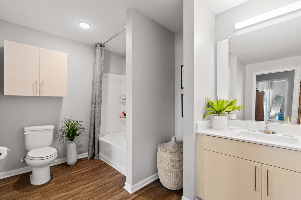 A white toilet sits next to a white sink in a small bathroom.