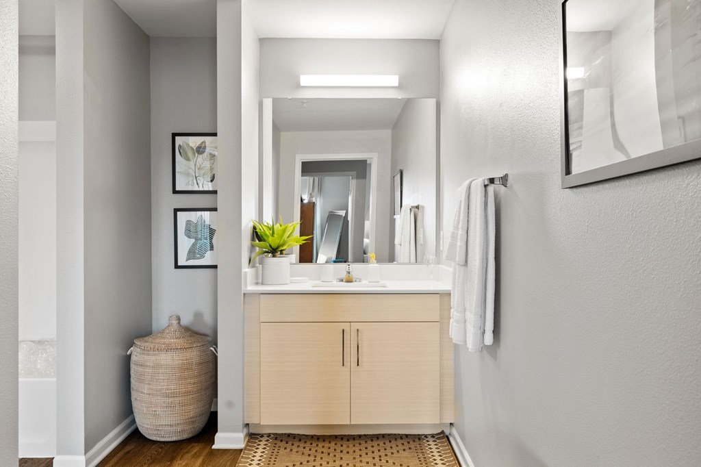 A bathroom with a sink, mirror, and cabinet.