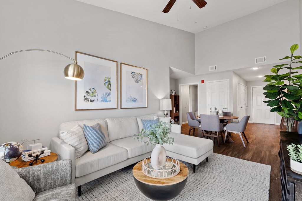 A living room with a white couch and a grey chair.