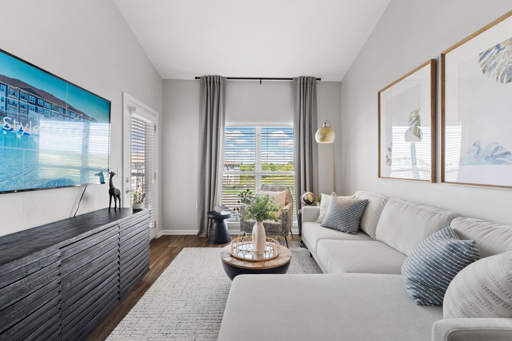 A modern living room with a large flat screen TV mounted on the wall.
