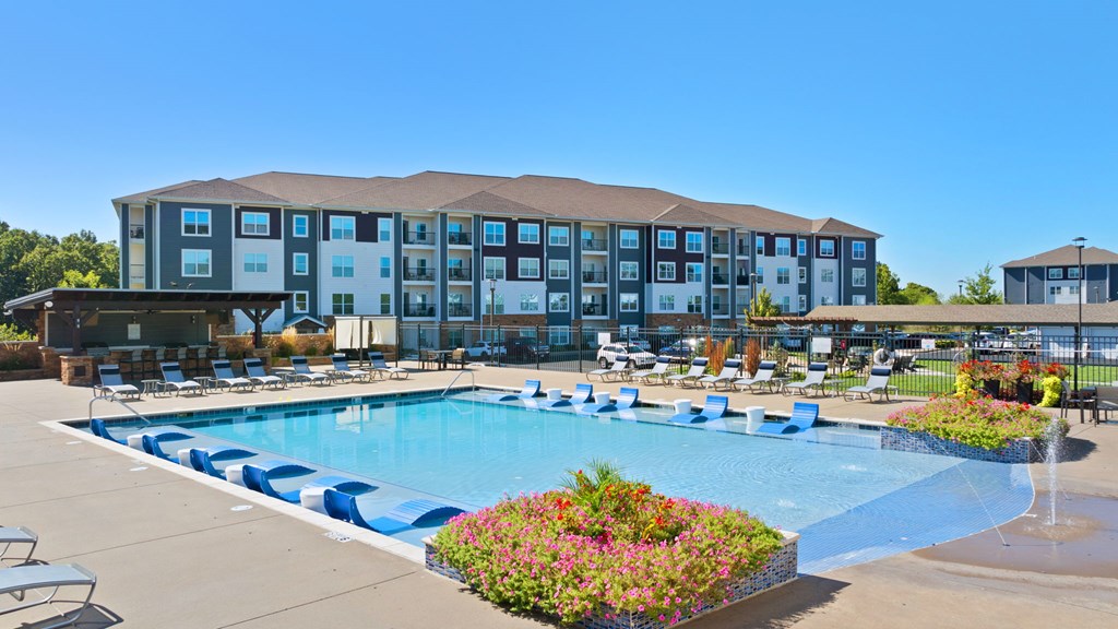A large hotel with a pool in front.