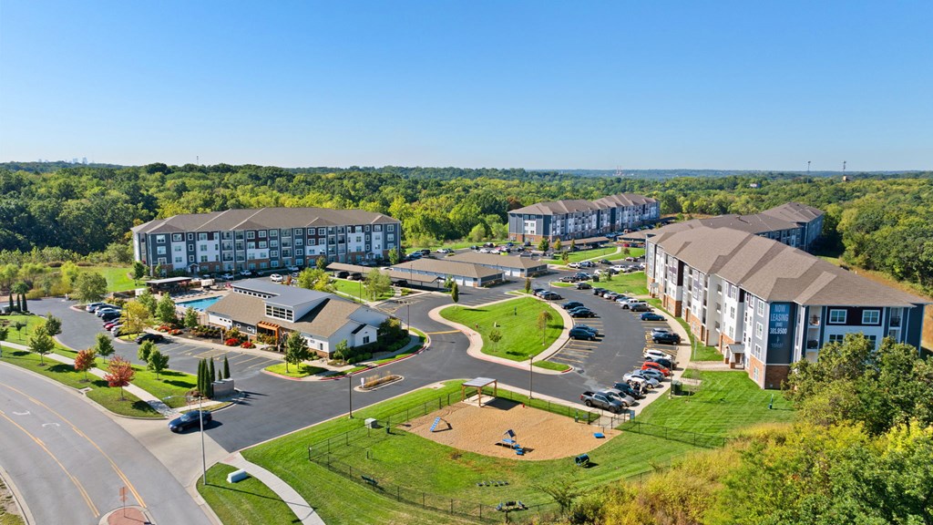 A large apartment complex with a parking lot in front.