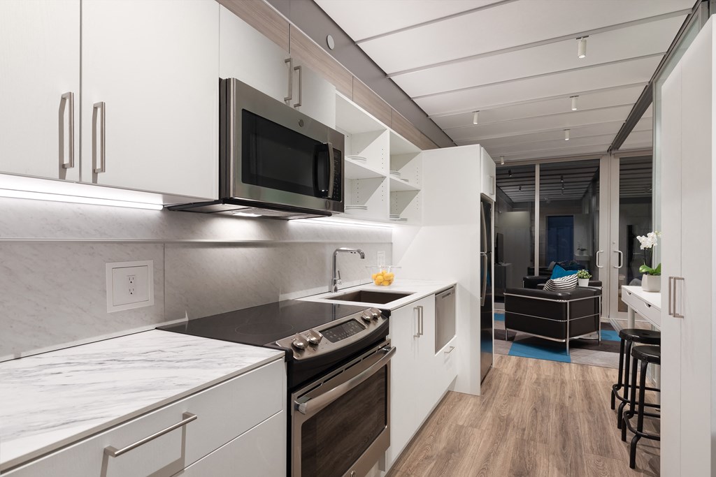 a kitchen with white cabinets and a black stove and a microwave