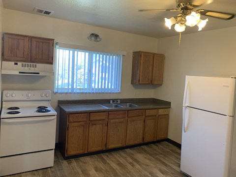 an empty kitchen with a stove refrigerator and sink