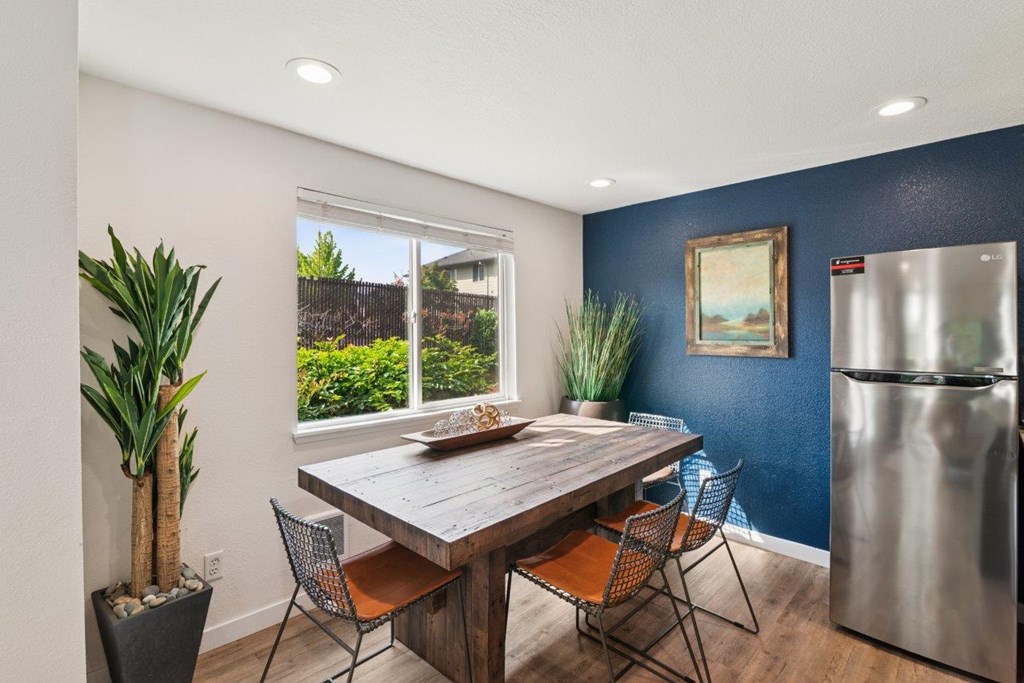 A dining room with a wooden table and chairs.