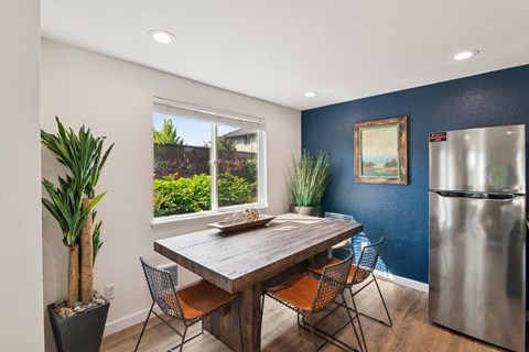 A dining room with a wooden table and chairs.