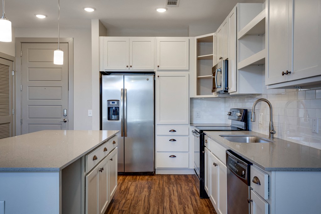 a kitchen with white cabinets and stainless steel appliances