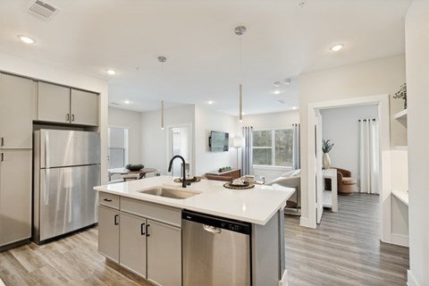 A modern kitchen with a stainless steel refrigerator and a white countertop.